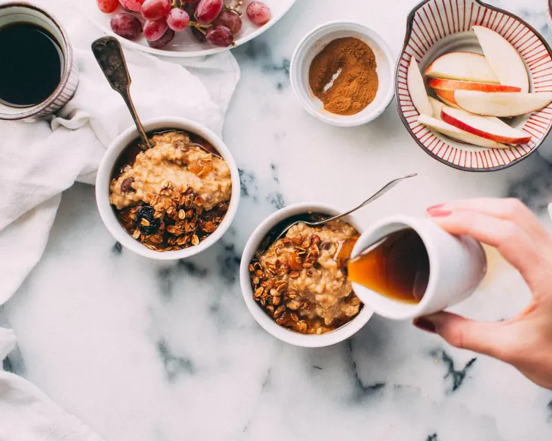 Cuencos de avena y miel sobre una mesa de mármol