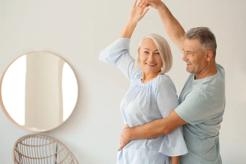 Pareja bailando en el salón de casa