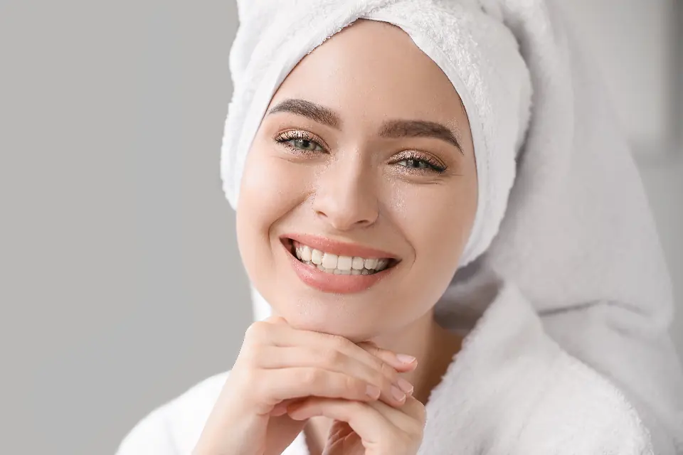 Mujer sonriente con una toalla en el pelo